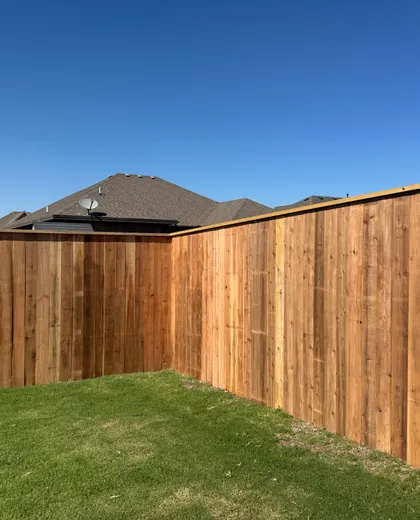 Freshly installed cedar privacy fence corner in a Lubbock, TX backyard by Hudson Fence Company